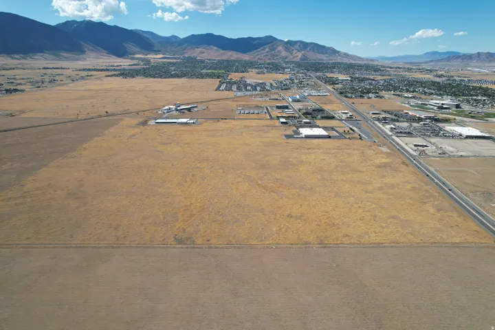 Expansive land parcel featuring a clear, level terrain and mountain backdrop