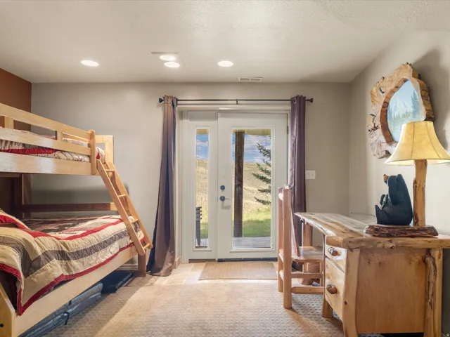 Bright bedroom retreat featuring wood-finish flooring, recessed ceiling lighting, and glass sliding doors opening to outdoor scenery