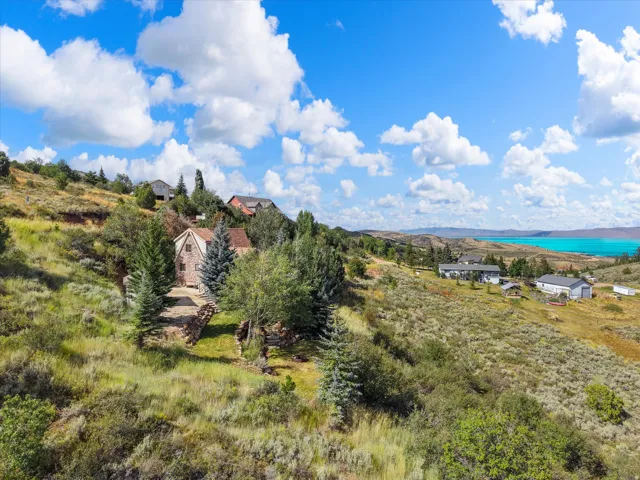 Hillside property with a stone facade, mature trees, and natural landscaping