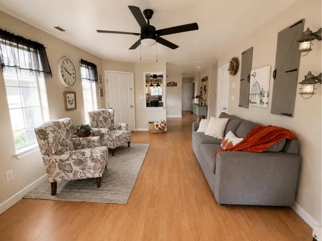 Wood-finish flooring, multiple windows, a ceiling fan with integrated lighting, and recessed lighting