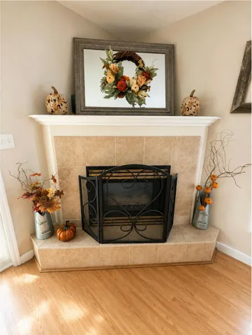 Fireplace featuring a tile hearth and mantel, with a decorative metal screen