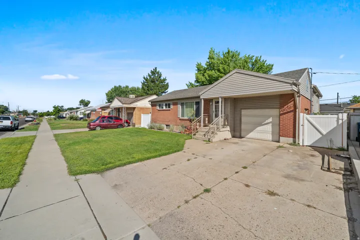 Brick and siding exterior with an attached garage, covered entry, and concrete driveway