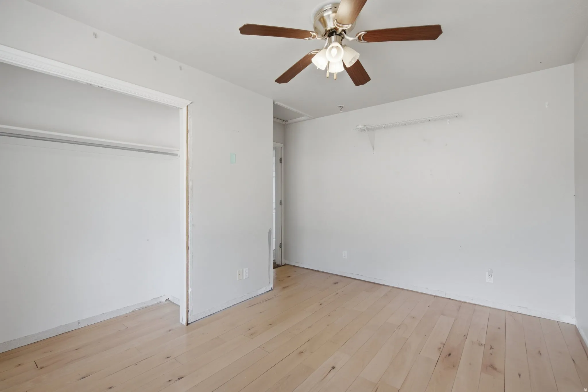Light wood-finish flooring with a ceiling fan