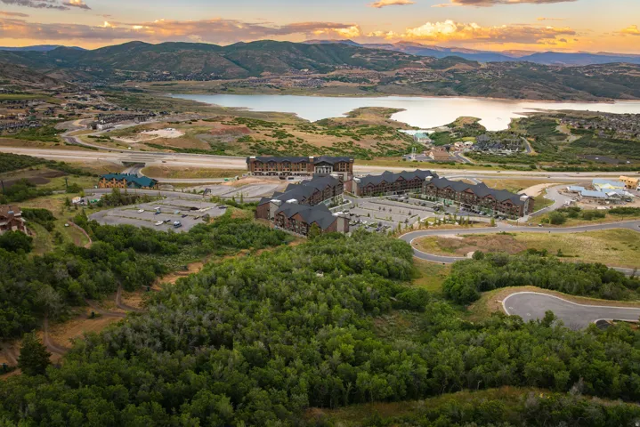 Expansive mountain landscape with a prominent lake, residential buildings, and surrounding green space