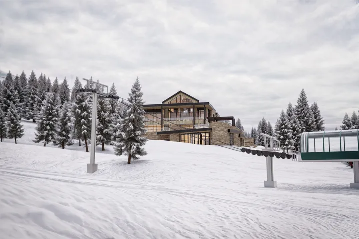 Modern mountain architecture with stone and wood finishes, expansive windows, multiple outdoor terrace areas, and a pitched roofline