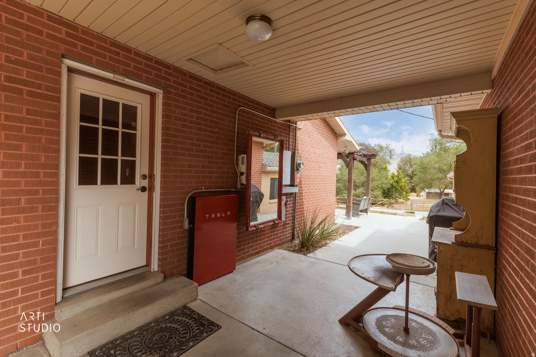 Covered patio with brick exterior walls and concrete flooring
