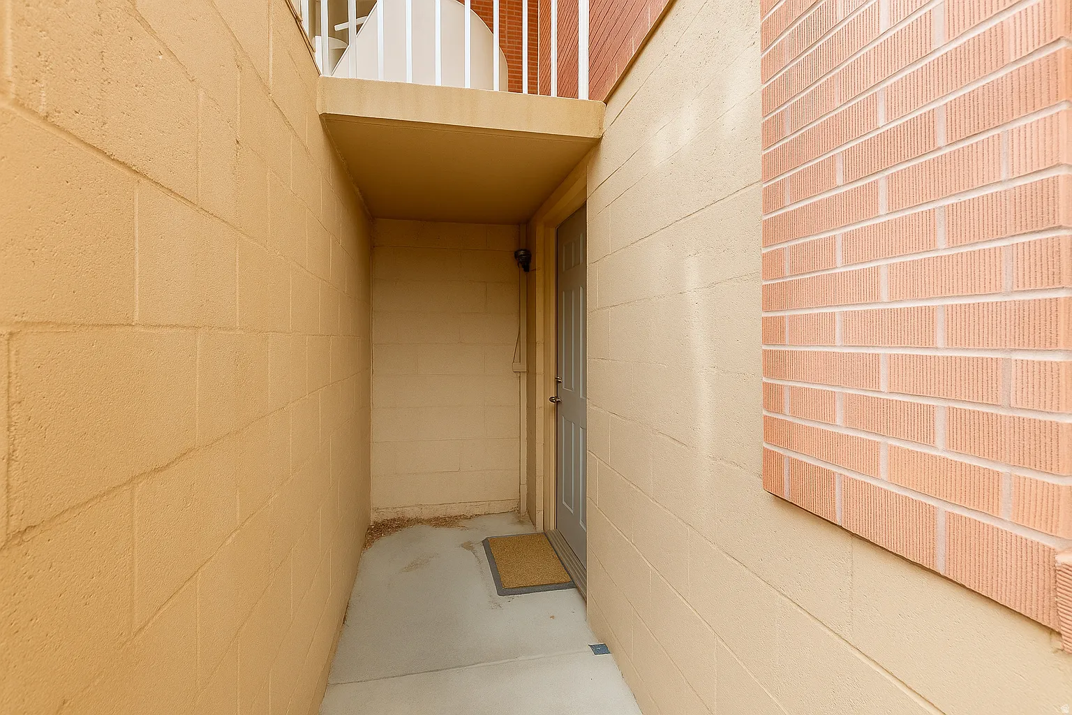 Entryway featuring a panel door, concrete walkway, and block wall construction