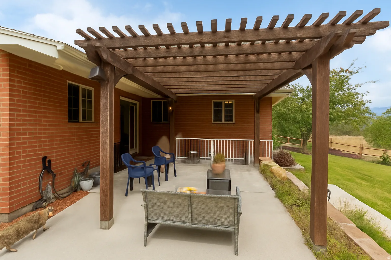Expansive outdoor patio featuring a wood pergola and concrete surface