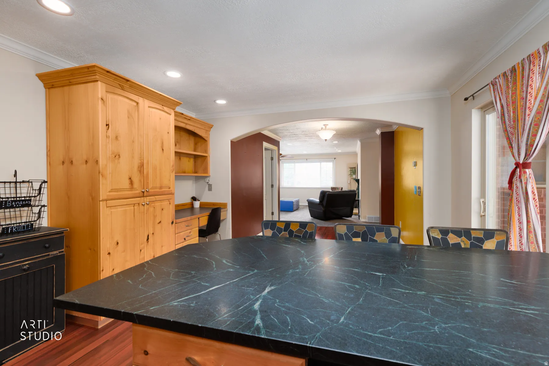 Built-in wood-finish cabinetry, solid surface countertop, recessed ceiling lighting, and wood-finish flooring