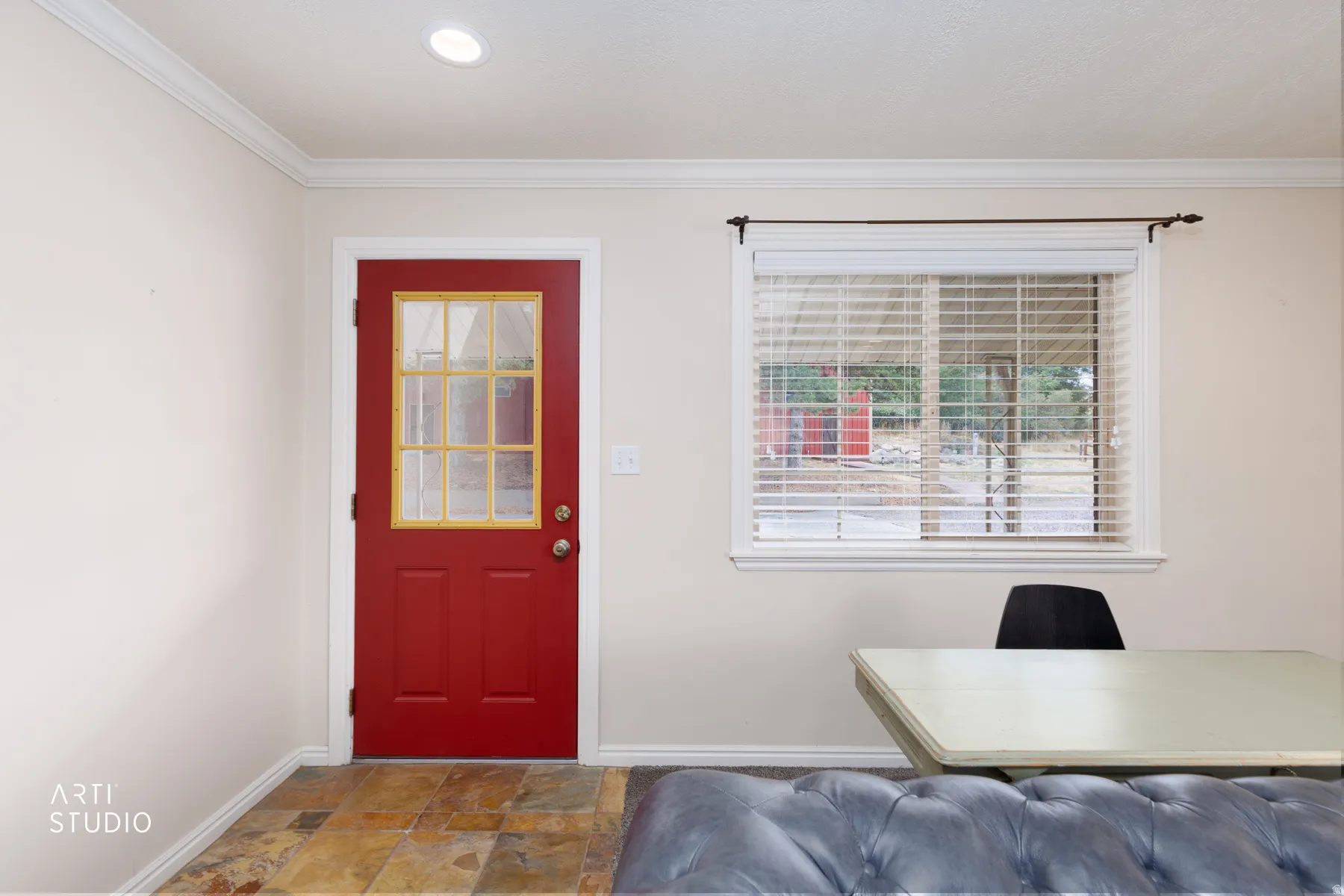 Red paneled door with glass inserts, recessed lighting, crown molding, and slate tile flooring