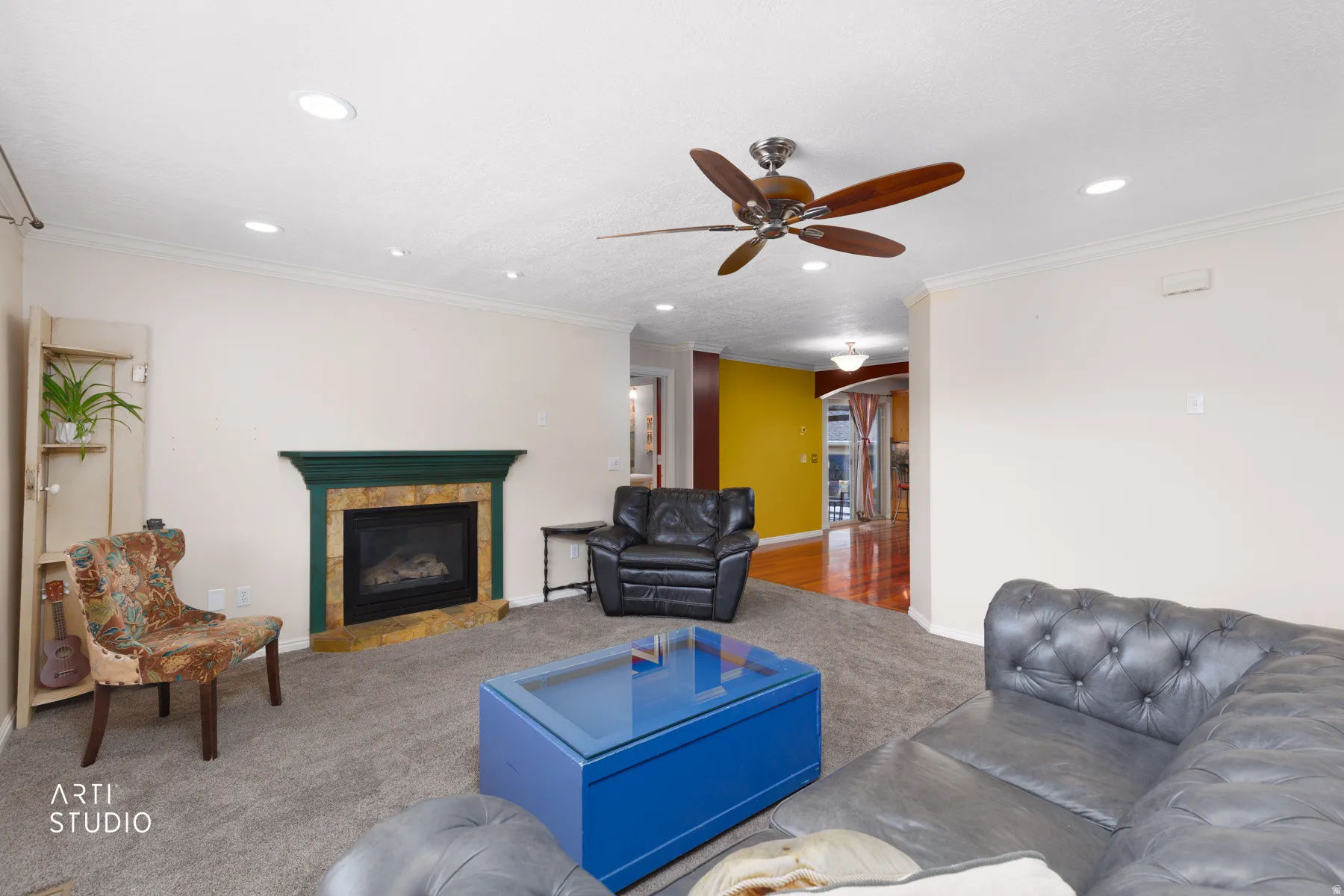 Living area featuring a gas fireplace with a stone surround, recessed lighting, and a ceiling fan
