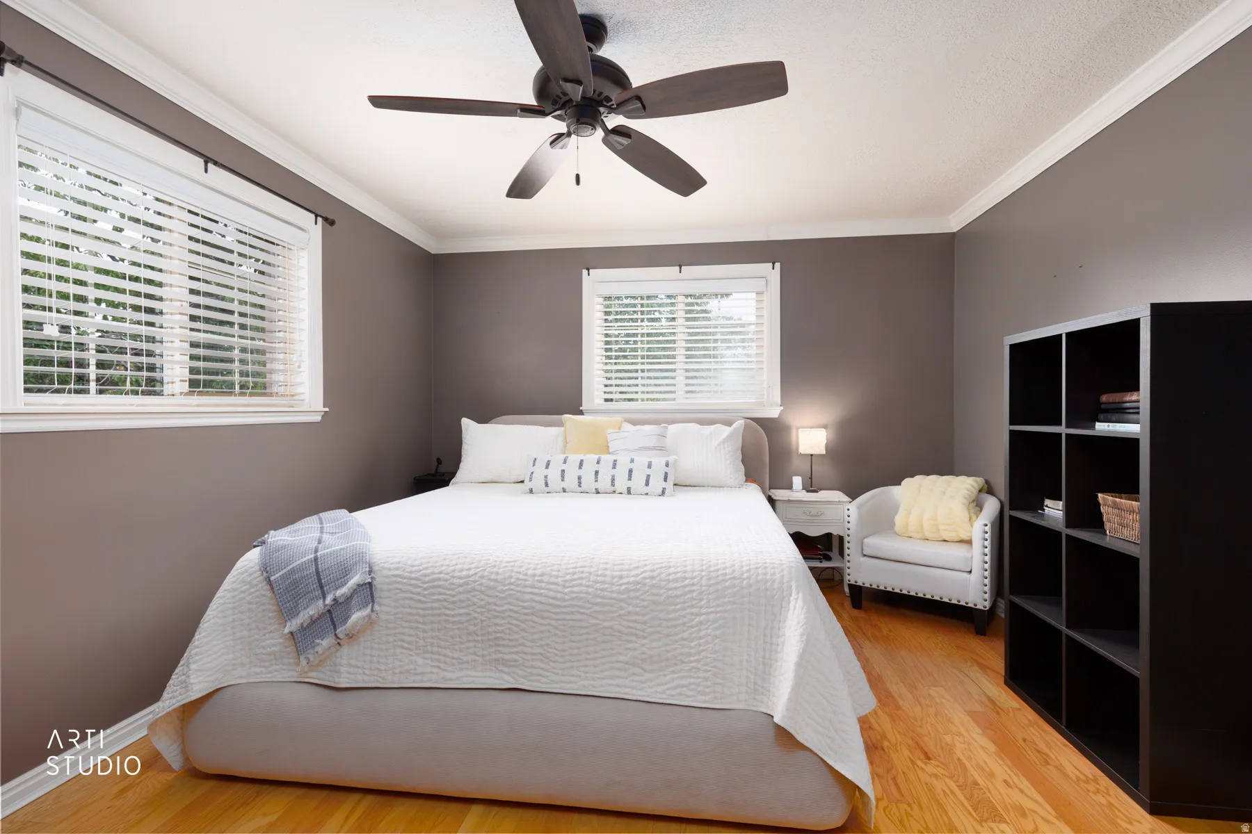 Hardwood flooring, painted walls, ceiling fan, crown molding, and multiple windows