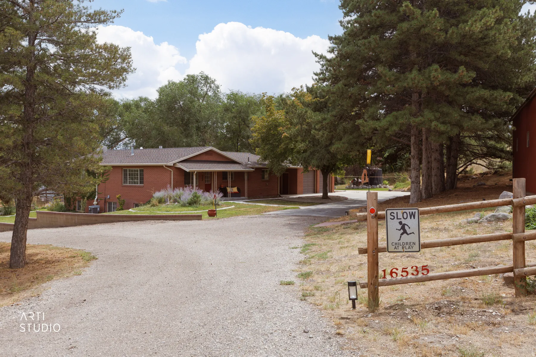 Brick exterior with a covered front porch and mature trees