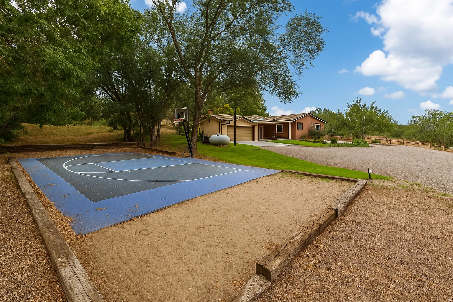 Sport court with painted surface, basketball hoop, gravel driveway, and manicured landscaping