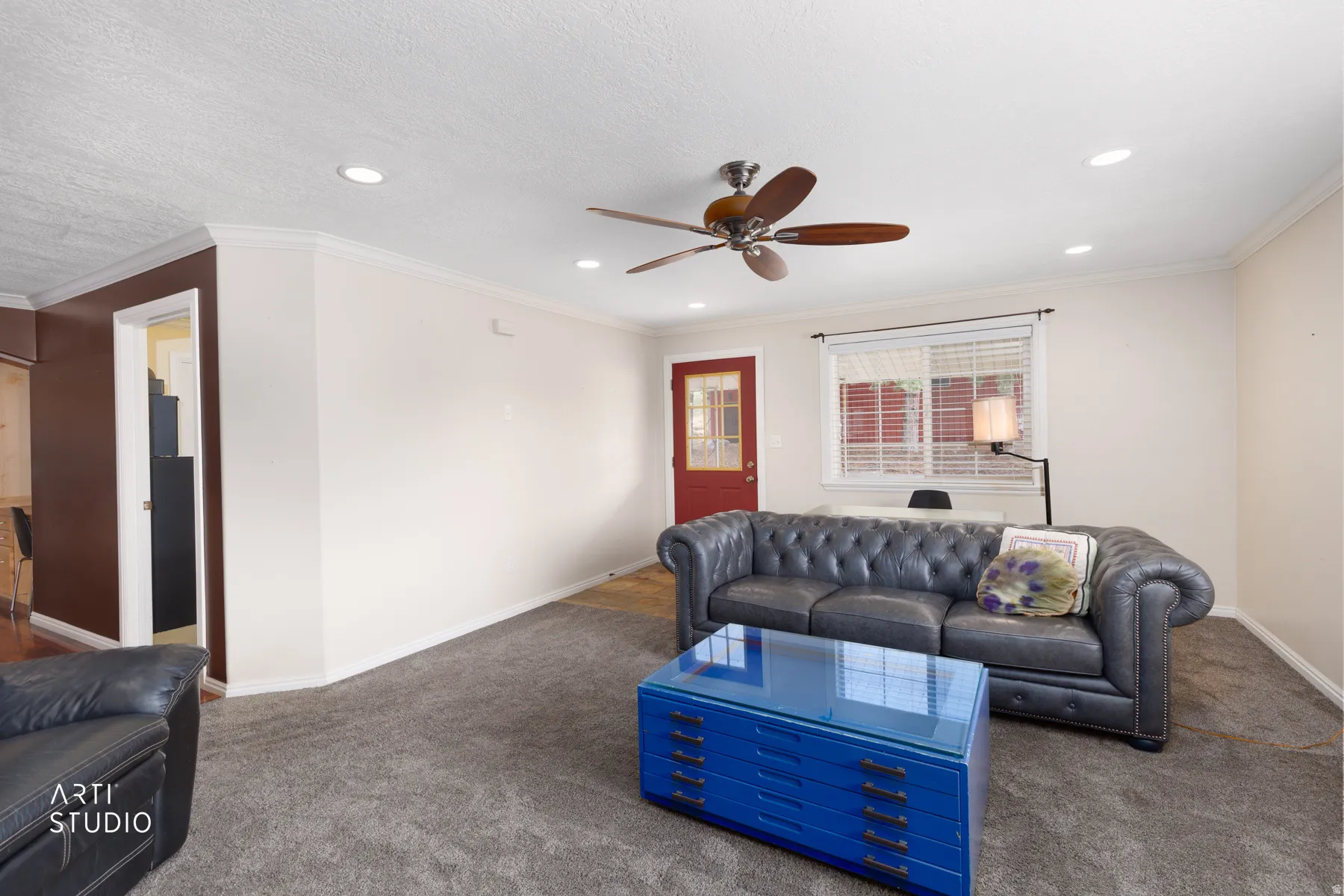 Recessed lighting, crown molding, ceiling fan, and a red-paneled door
