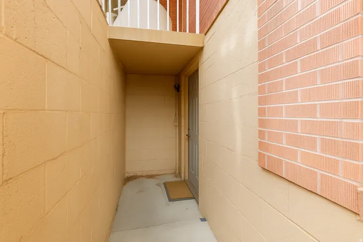 Entryway featuring a panel door, concrete walkway, and block wall construction