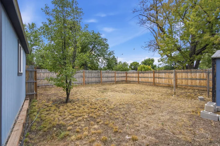 Private backyard with wood fencing, mature trees, and a detached shed