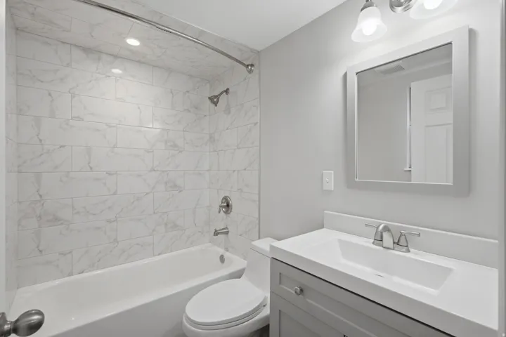 Vanity with integrated sink, framed mirror, and chrome fixtures