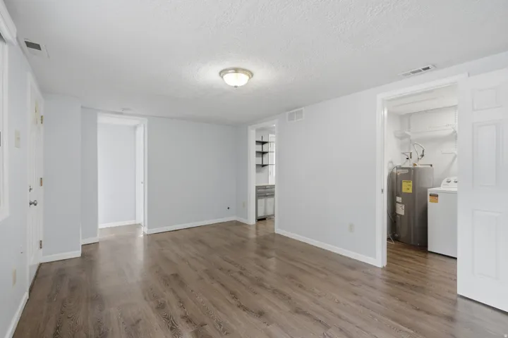 Wood-finish flooring throughout, white trim, and a ceiling-mounted light fixture