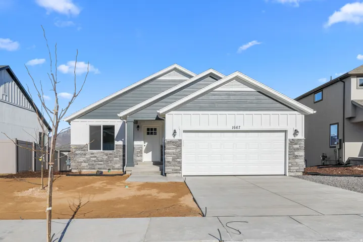 Modern exterior featuring a two-car garage, stone and siding facade, and a covered entry