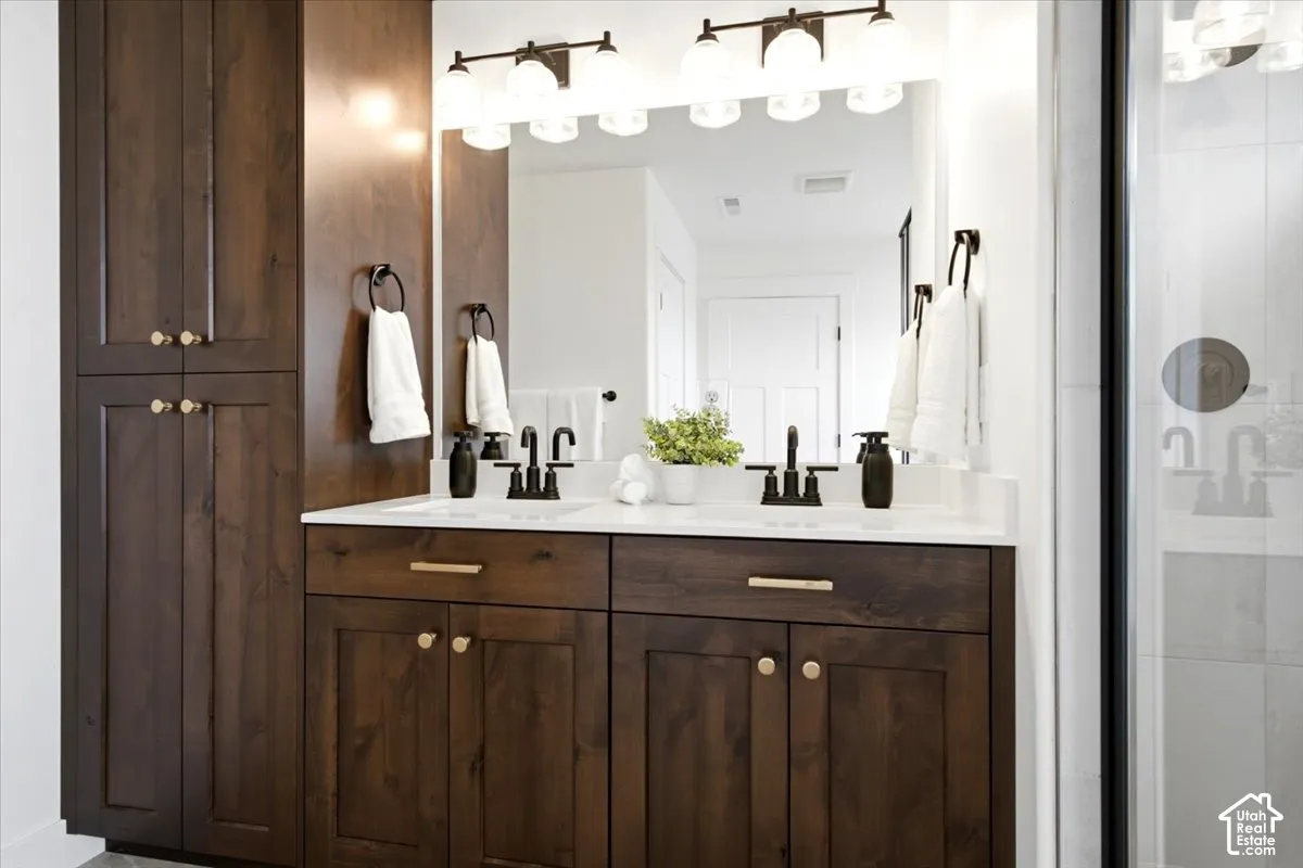 Dual vanity with wood cabinetry, white countertop, and matte black fixtures