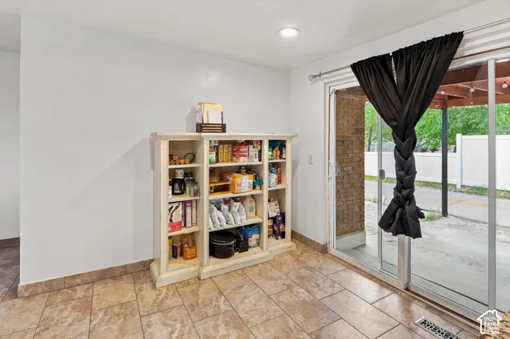 Slider door with outdoor access, recessed ceiling lighting, and tiled flooring