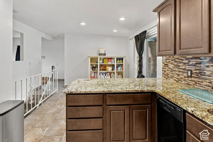 Kitchen featuring granite countertops, wood-finish cabinetry, built-in dishwasher, and a mosaic tile backsplash