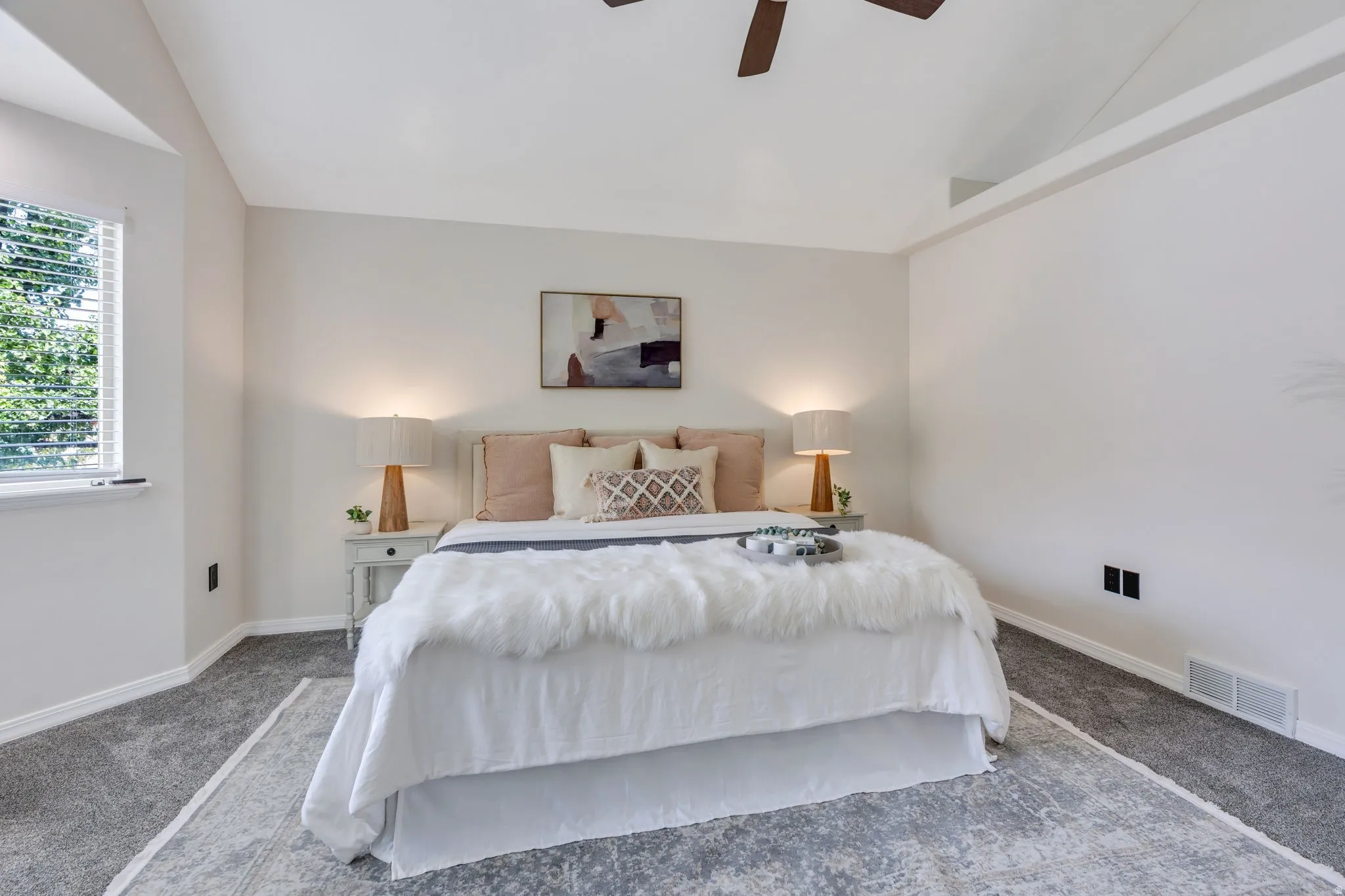 Vaulted ceiling with a ceiling fan, carpeted flooring, and a large window with blinds