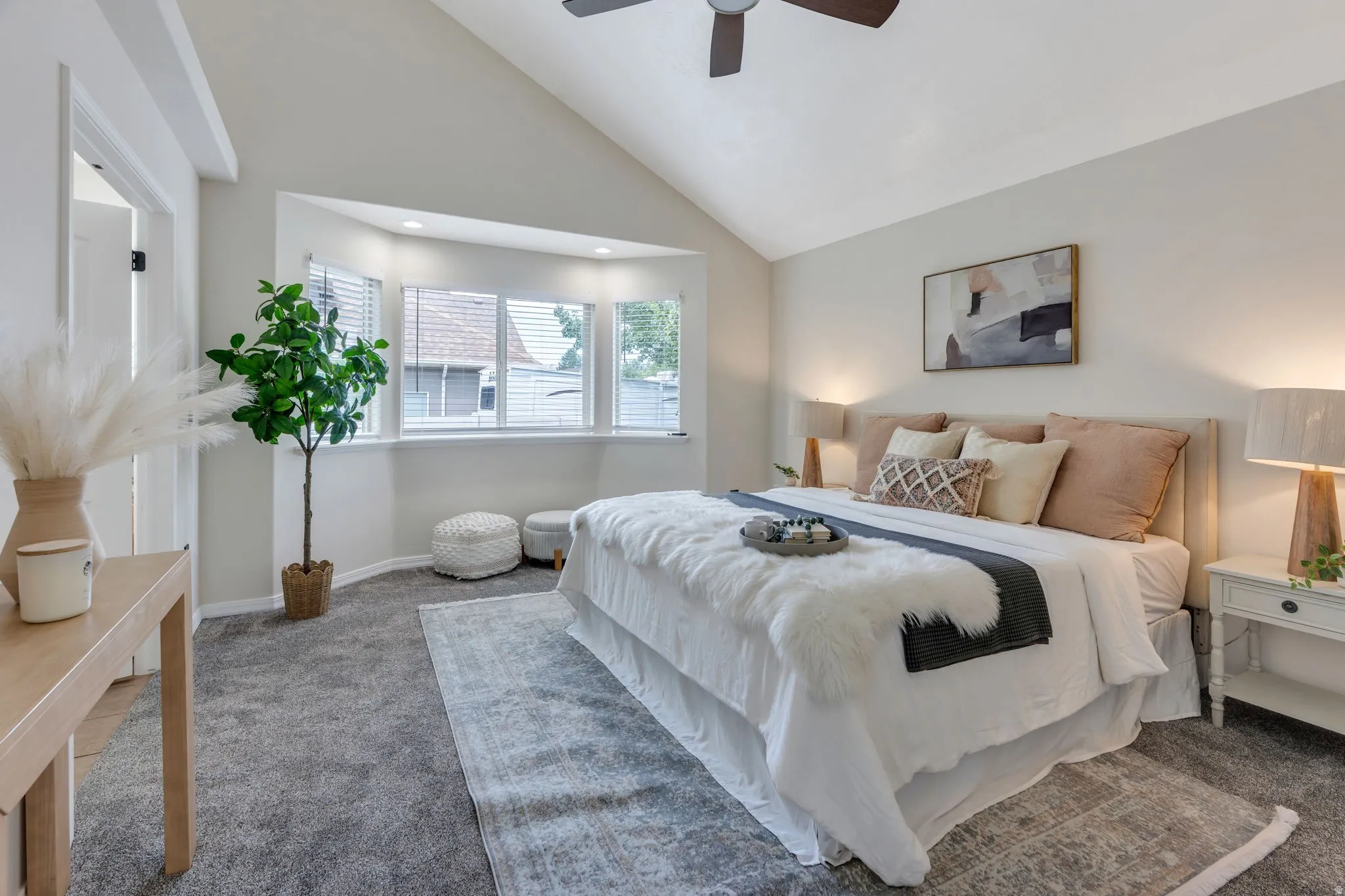 Vaulted ceiling with a ceiling fan, recessed lighting, bay window, and gray carpet flooring