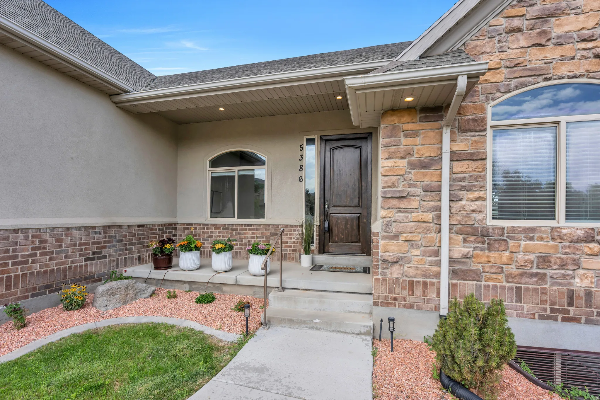 Stone and stucco exterior with brick accenting