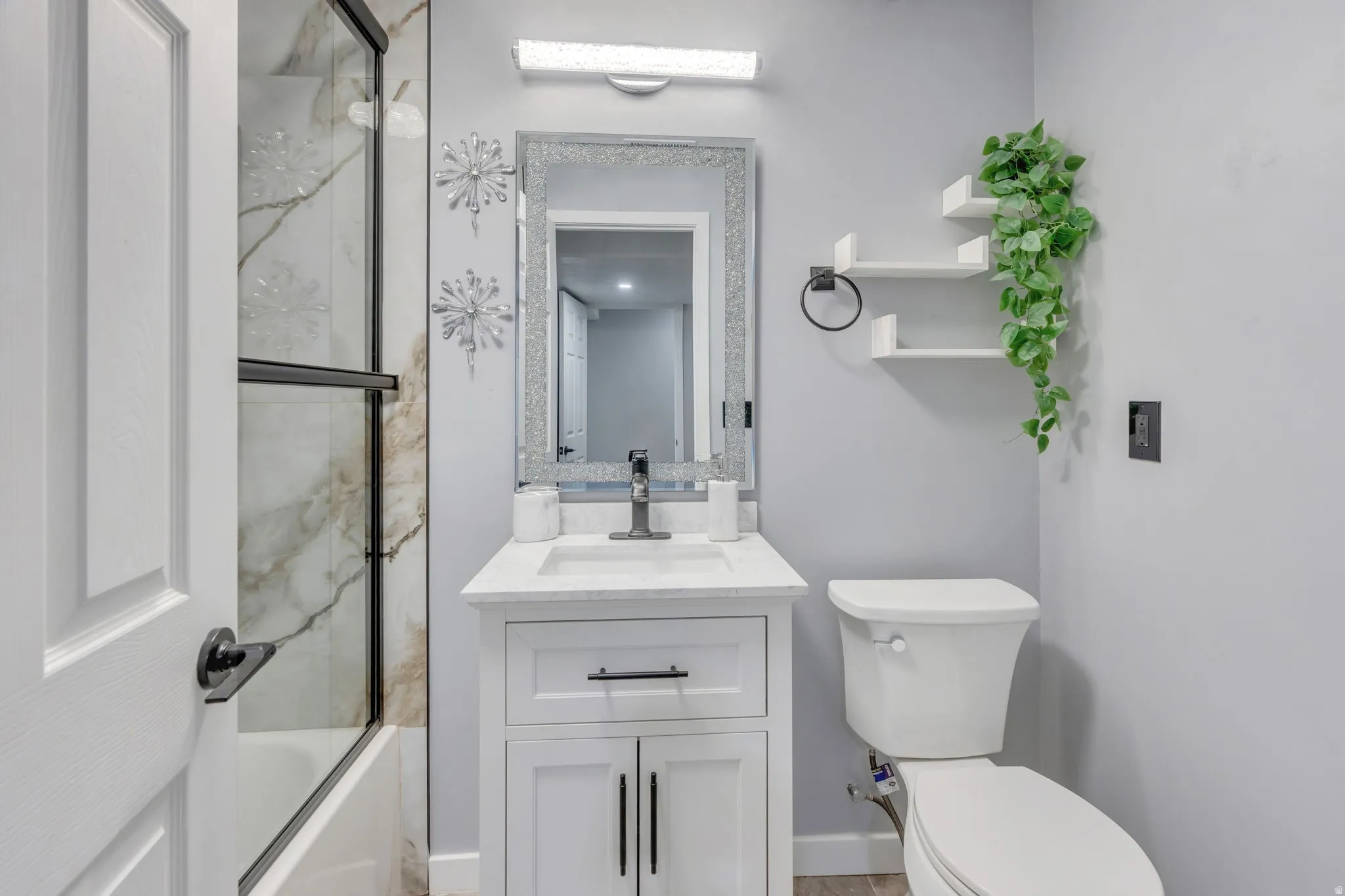 White shaker-style vanity with a single basin sink and black-finish faucet