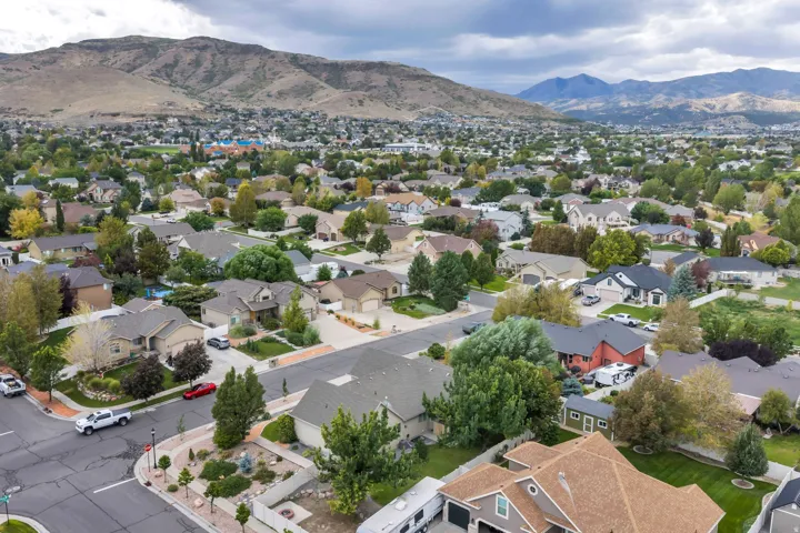 Residential neighborhood with diverse home styles and mature landscaping, framed by distant mountains