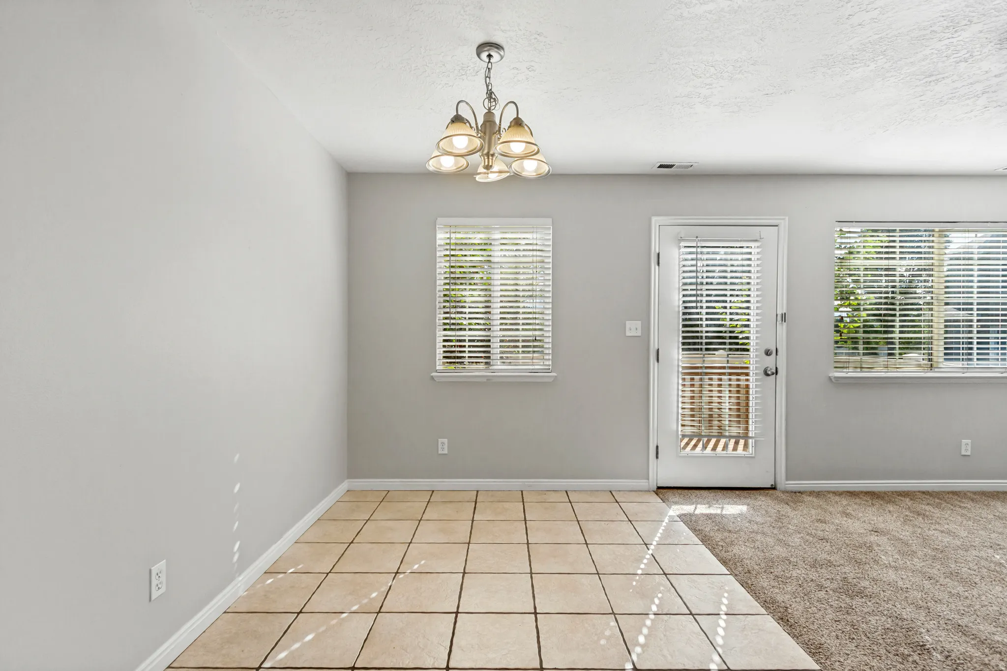 Recessed lighting, tile flooring, and neutral wall tones
