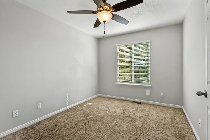 Neutral-toned walls complement the textured carpet flooring