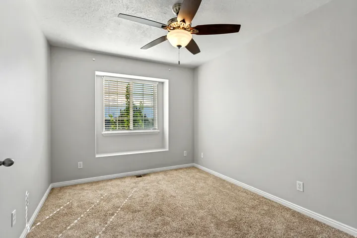 Recessed window with white trim, ceiling fan with integrated lighting, and carpeted flooring