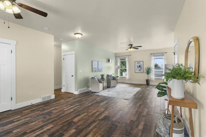Wood-finish flooring throughout, ceiling fans, multiple windows providing natural light, white interior doors, and white trim