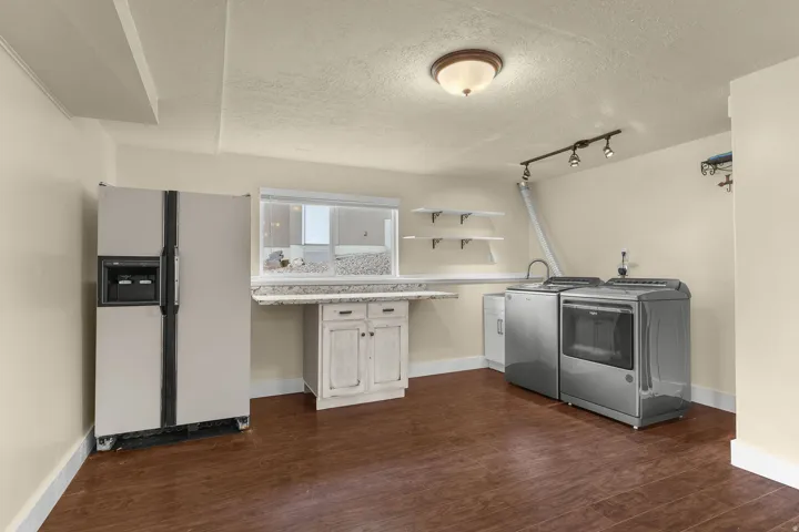Wood-finish flooring with track lighting and a ceiling-mounted fixture