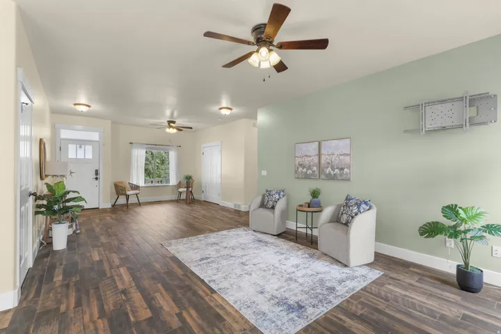 Wood-finish flooring throughout, ceiling fans, recessed lighting, and a front entry door with transom window
