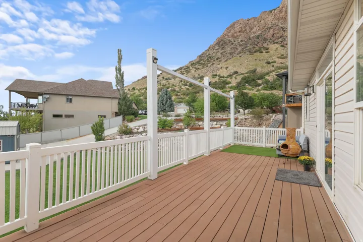 Expansive deck featuring composite decking, white railing, and a partial pergola structure