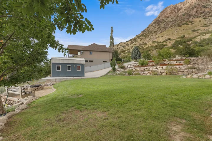 Expansive lawn area with a stone retaining wall and tiered landscaping