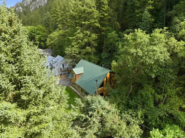 Wood-sided residence featuring a green metal roof