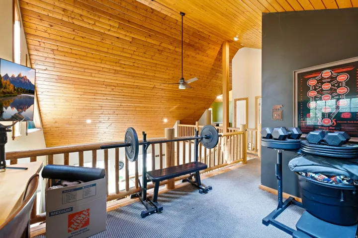 Wood-paneled vaulted ceiling with a ceiling fan, exposed wood beams, and recessed lighting