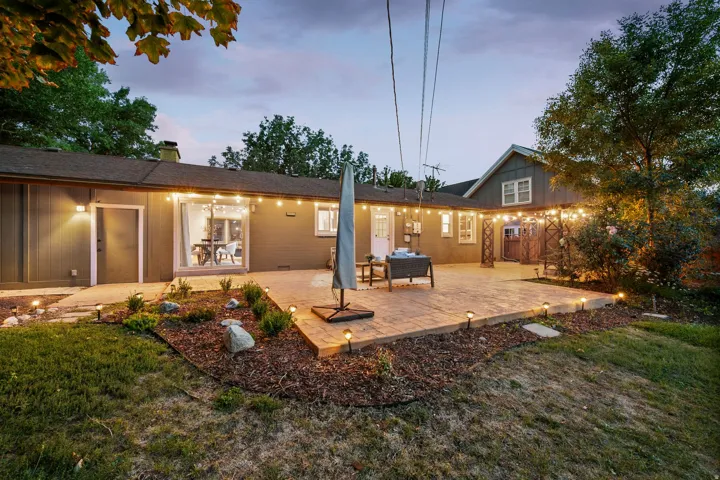 Expansive paver patio with string lighting and dedicated outdoor lighting