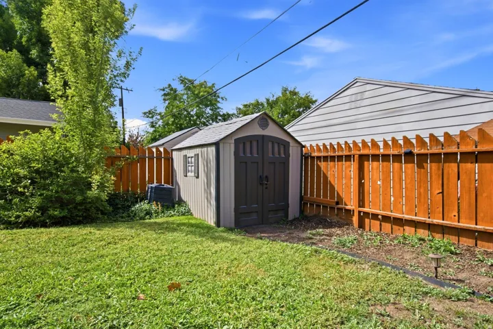 Manicured lawn, established landscaping, and a wood privacy fence