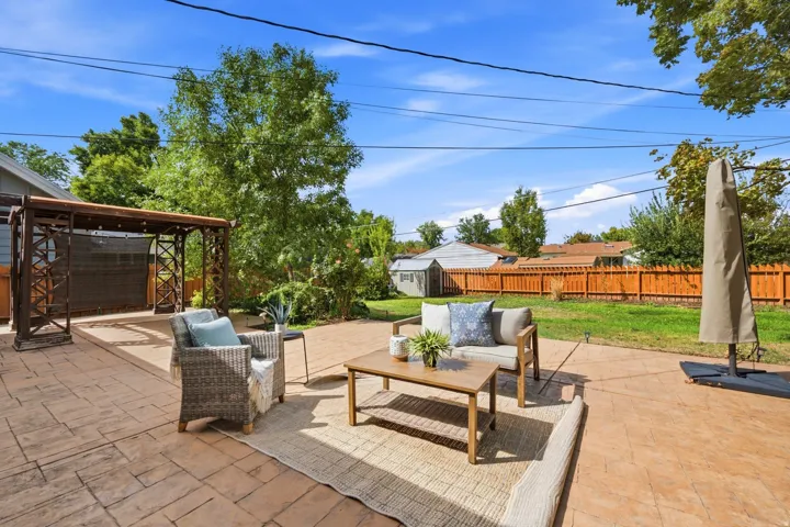 Expansive patio featuring stamped concrete, a wooden pergola, and a private wooden fence