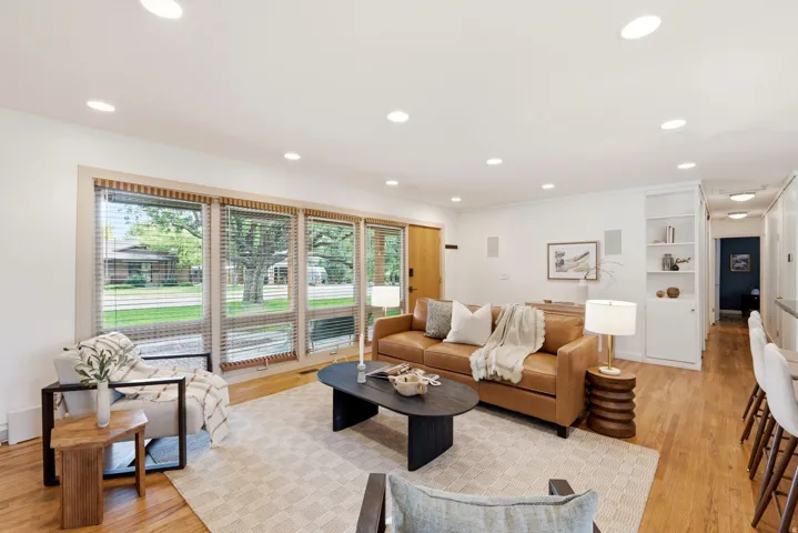 Recessed lighting, wood-finish flooring, built-in shelving, and extensive windows with blinds