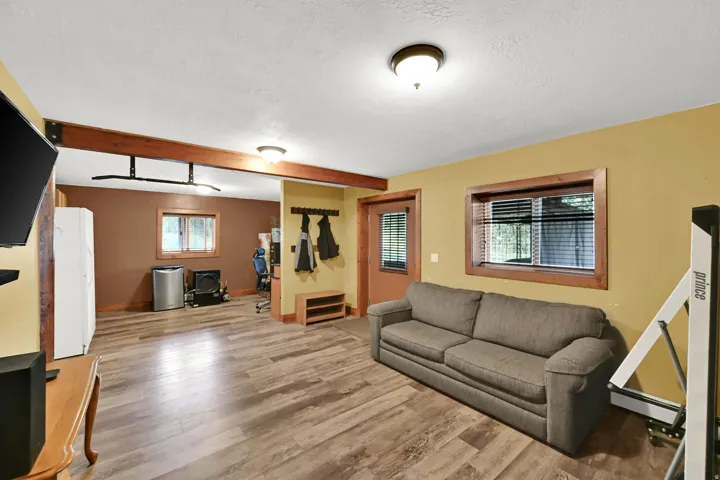 Wood-finish flooring, exposed wood beams, and a wood-paneled door