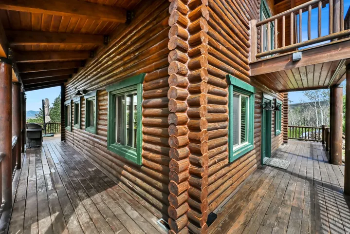 Log construction exterior with a wrap-around wood deck