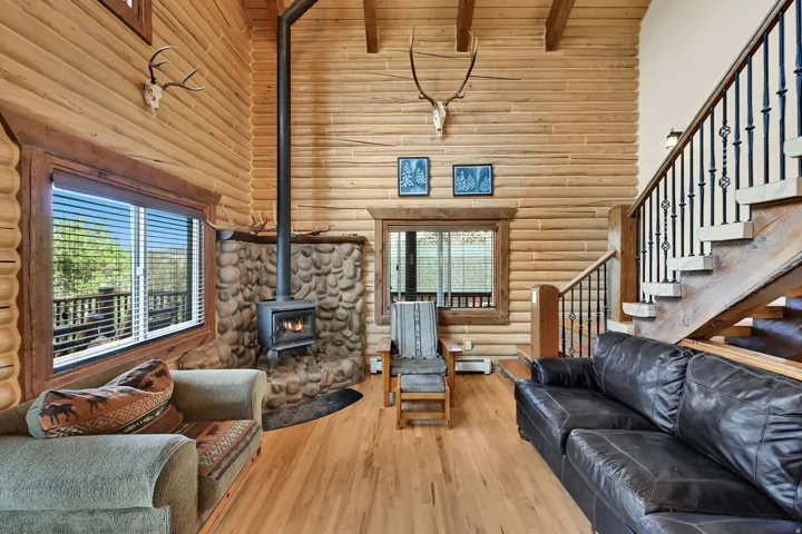 Tongue-and-groove wood plank walls, hardwood flooring, and exposed ceiling beams