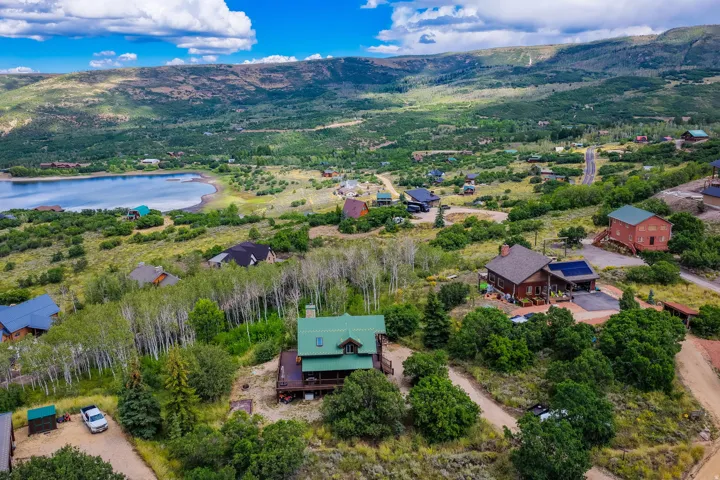 Lakeside community featuring varied architectural styles and mature trees, set against a mountainous backdrop